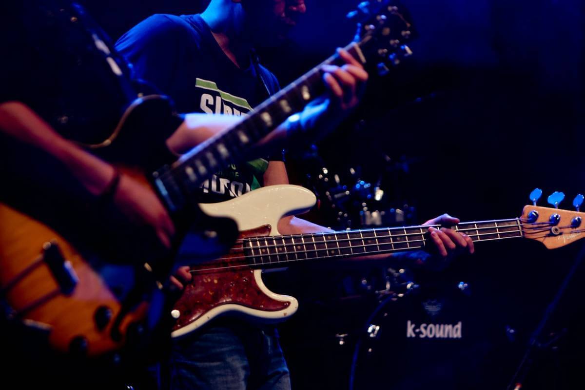 two guitarists perform in a recording studio 